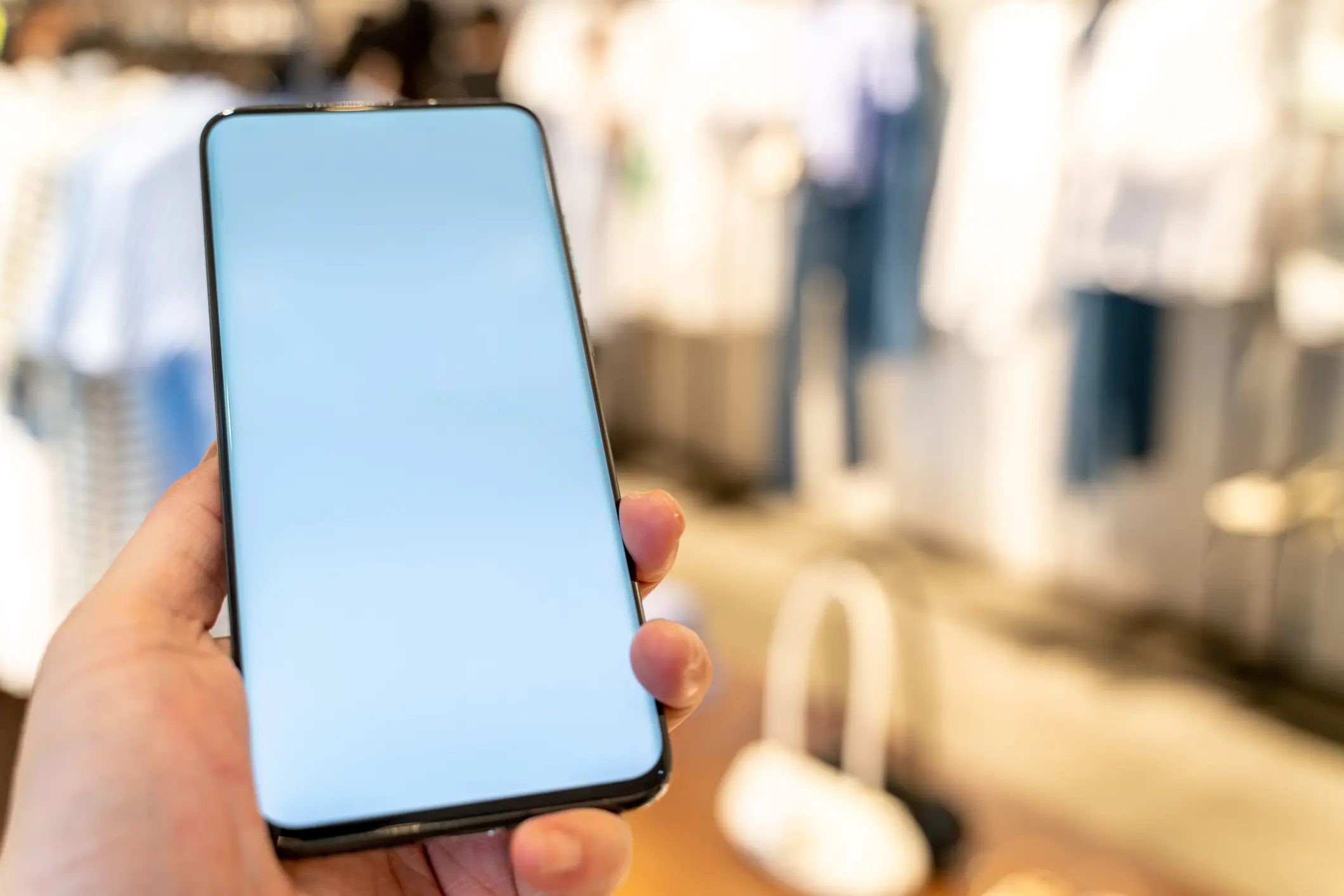 A shot of a hand, holding a mobile phone for mockups